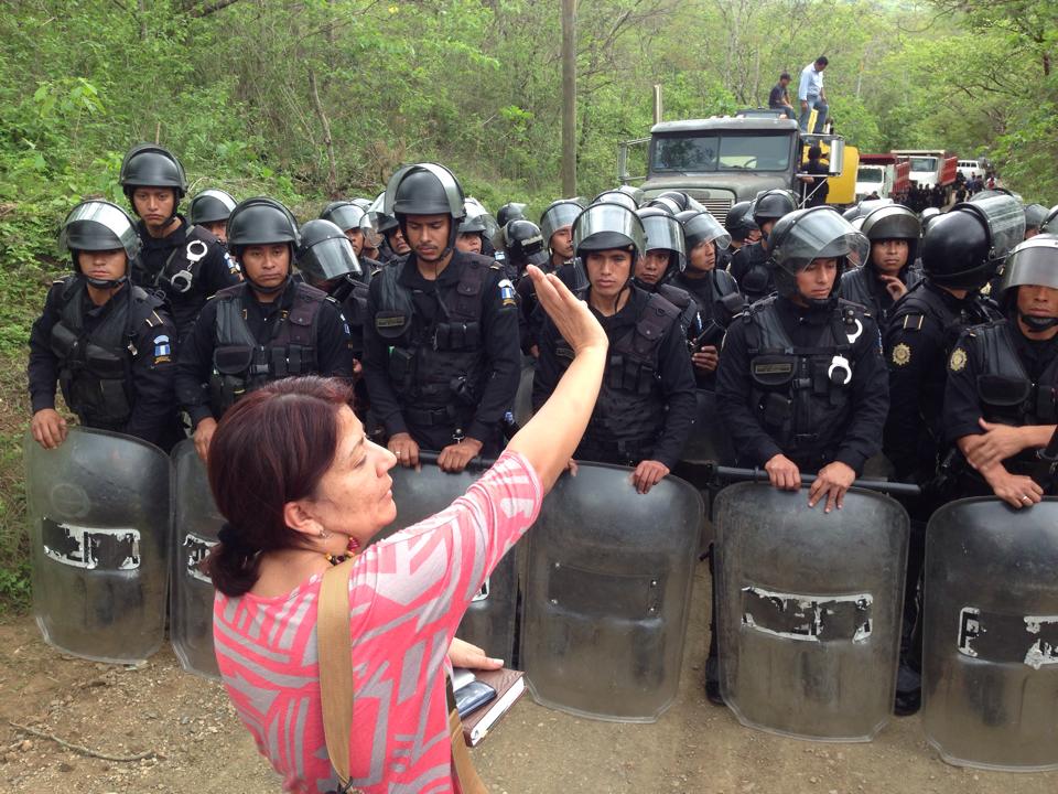 Community leader Yolanda Oqueli urges the riot police not to use violence against the men, women, and children protesting the construction of a gold mine at La Puya. Photo via GHRC