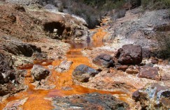 acid drains from the Rio Tinto River, turning the water a bright copper color