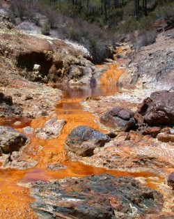 acid drains from the Rio Tinto River, turning the water a bright copper color