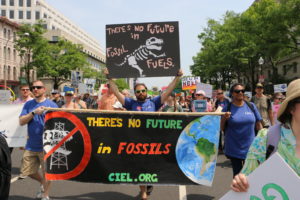 CIEL staff at People's Climate March, holding signs saying "There's no future in fossil fuels."