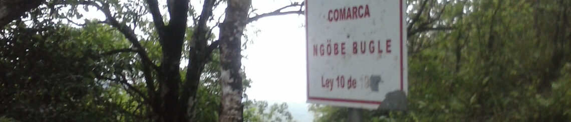 Image of a forest in Panama. In the foreground is a sign that announces the beginning of the Comarca Ngäbe Bugle.