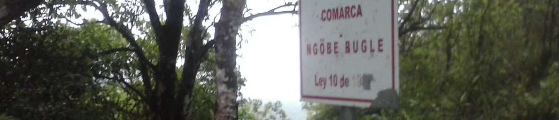 Image of a forest in Panama. In the foreground is a sign that announces the beginning of the Comarca Ngäbe Bugle.