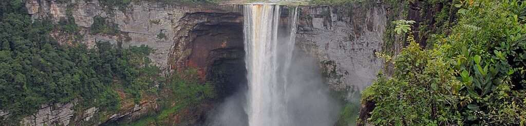 Kaieteur Falls, a waterfall cutting through lush tropical forest.