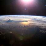 a view of earth from space and the sun